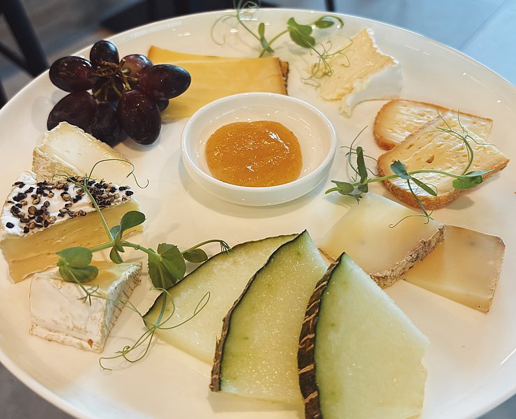 Feine Käseauswahl mit frischen Trauben, Melone und Honig – Natur-Genuss-Tour in Dernau im Ahrtal.