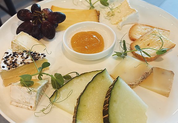 Feine Käseauswahl mit frischen Trauben, Melone und Honig – Natur-Genuss-Tour in Dernau im Ahrtal.